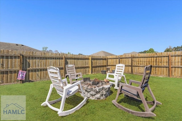 view of yard with a fenced backyard and a fire pit
