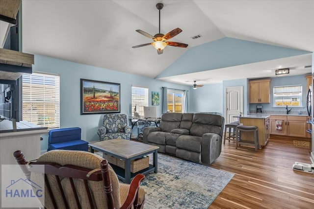 living room with ceiling fan, visible vents, a wealth of natural light, and wood finished floors