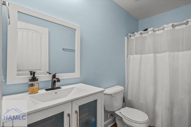 bathroom with toilet, vanity, and a shower with curtain