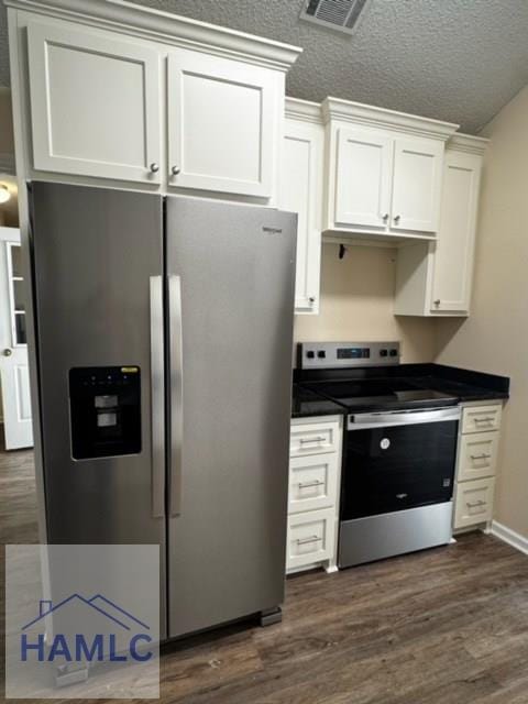 kitchen with stainless steel appliances, dark hardwood / wood-style floors, a textured ceiling, and white cabinets