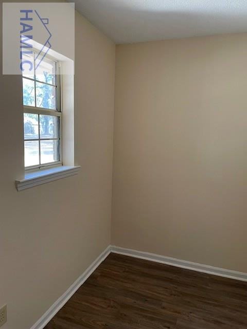 empty room with dark hardwood / wood-style flooring