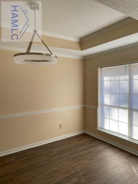 unfurnished room featuring dark wood-type flooring, ornamental molding, and a textured ceiling