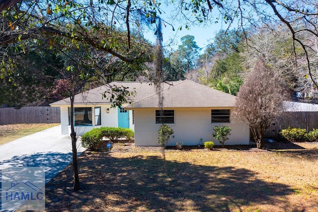 ranch-style home with brick siding, a front yard, and fence