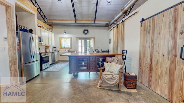 26 Cason Rd, Pembroke, GA 31321 - kitchen featuring stainless steel appliances, finished concrete flooring, light countertops, white cabinets, and a barn door