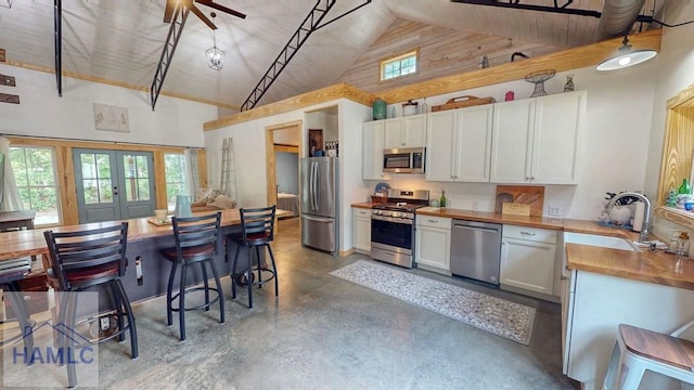26 Cason Rd, Pembroke, GA 31321 - kitchen featuring stainless steel appliances, high vaulted ceiling, concrete floors, french doors, and white cabinets