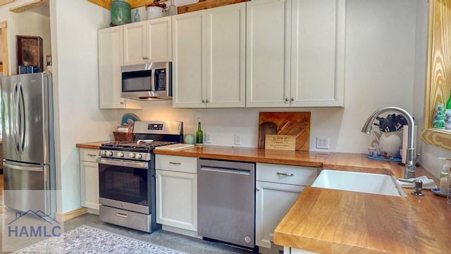 26 Cason Rd, Pembroke, GA 31321 - kitchen with stainless steel appliances, wood counters, and white cabinetry