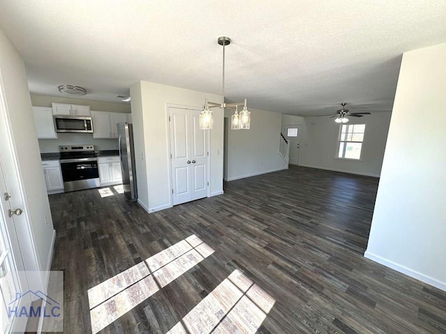 interior space featuring ceiling fan, dark hardwood / wood-style floors, and a textured ceiling