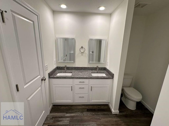 bathroom with hardwood / wood-style flooring, vanity, and toilet