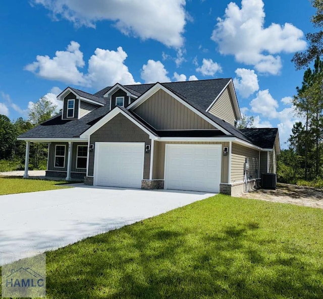 view of front of home with cooling unit, a garage, and a front lawn