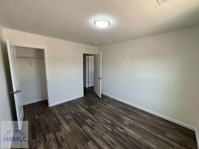 unfurnished bedroom with dark wood-type flooring, a closet, and a textured ceiling