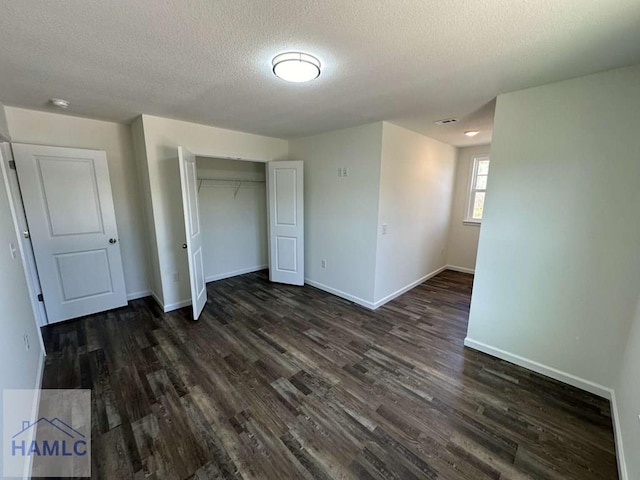 unfurnished bedroom featuring dark hardwood / wood-style floors, a closet, and a textured ceiling