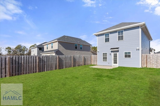 rear view of property with a lawn, a patio, and a fenced backyard