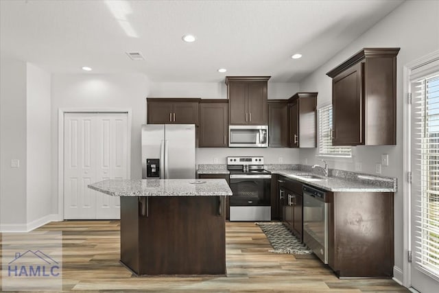 kitchen featuring visible vents, a kitchen island, recessed lighting, dark brown cabinetry, and appliances with stainless steel finishes