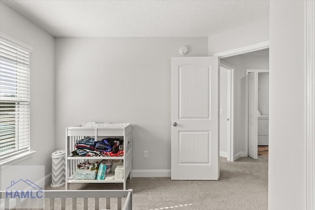 carpeted bedroom featuring multiple windows, baseboards, and a textured ceiling