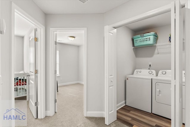 laundry room with washer and dryer, laundry area, baseboards, and light carpet