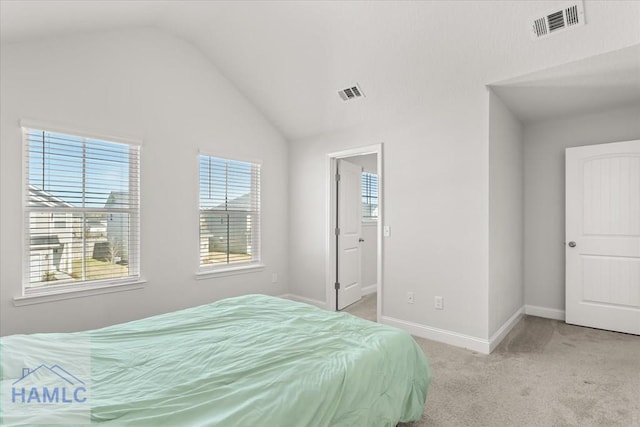 bedroom featuring visible vents, lofted ceiling, and light carpet