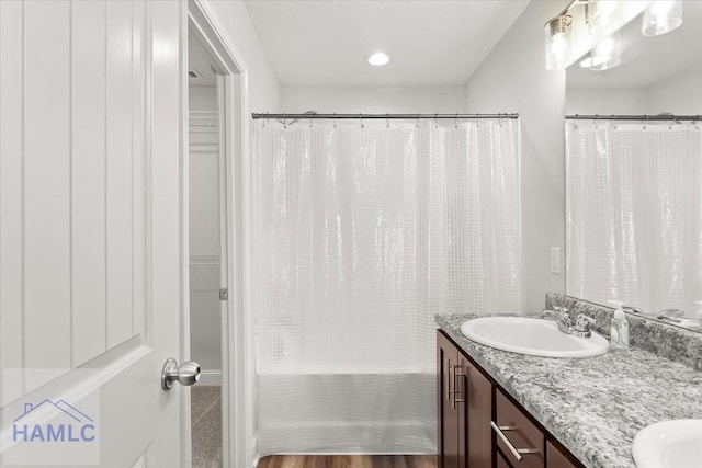 full bathroom featuring a sink, shower / bathtub combination with curtain, and double vanity