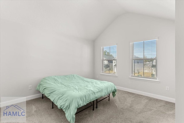 carpeted bedroom featuring baseboards and vaulted ceiling