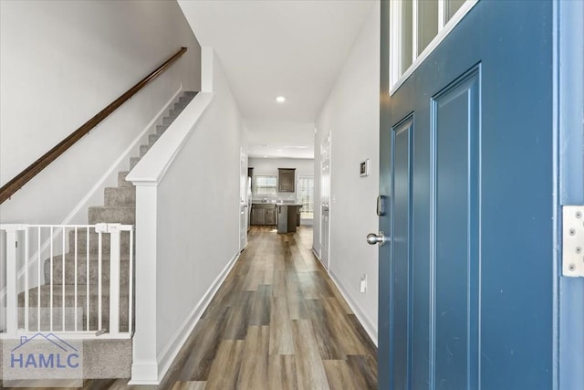 interior space featuring stairs, recessed lighting, wood finished floors, and baseboards