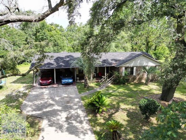 455 N Mahogany St, Jesup, GA 31546 - ranch-style house featuring concrete driveway, a trampoline, a front yard, a carport, and a shingled roof