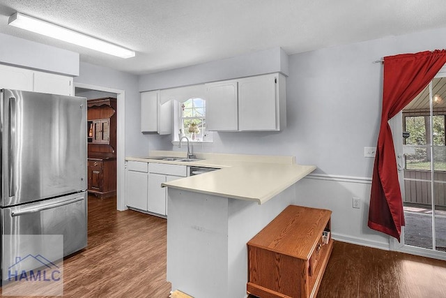 209 Chandra Way, Hinesville, GA 31313 - kitchen featuring freestanding refrigerator, a sink, dark wood-style flooring, a peninsula, and a textured ceiling