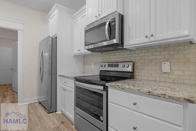 791 Stafford Dairy Rd SE, Ludowici, GA 31316 - kitchen with appliances with stainless steel finishes, light wood finished floors, white cabinetry, decorative backsplash, and light stone countertops