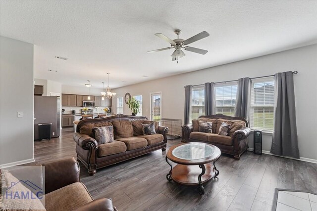 263NE Summer Hill Dr, Ludowici, GA 31316 - living area with ceiling fan, a chandelier, dark wood-style flooring, baseboards, and a textured ceiling