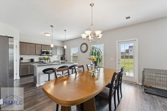263NE Summer Hill Dr, Ludowici, GA 31316 - dining area featuring dark wood finished floors, a chandelier, and baseboards