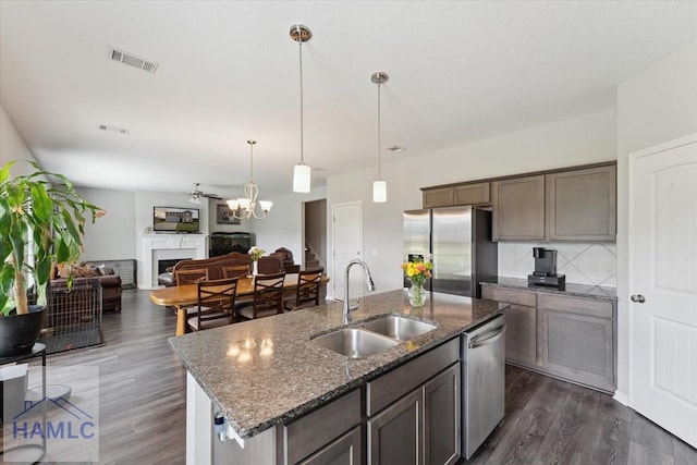 263NE Summer Hill Dr, Ludowici, GA 31316 - kitchen featuring stainless steel appliances, a sink, tasteful backsplash, dark wood-type flooring, and dark stone countertops