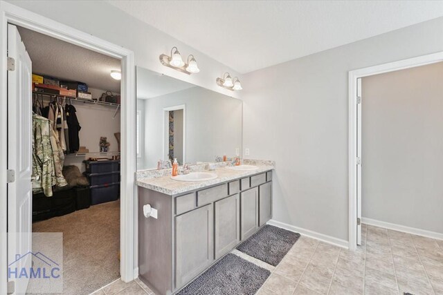 263NE Summer Hill Dr, Ludowici, GA 31316 - full bath with double vanity, a walk in closet, and baseboards