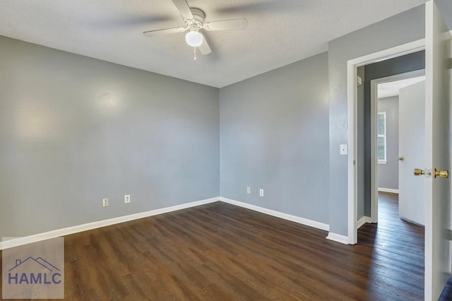 empty room featuring ceiling fan, dark wood-type flooring, and a textured ceiling