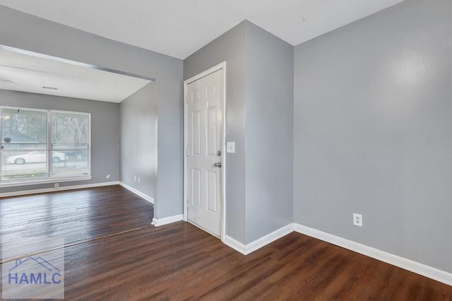 empty room with dark wood-type flooring