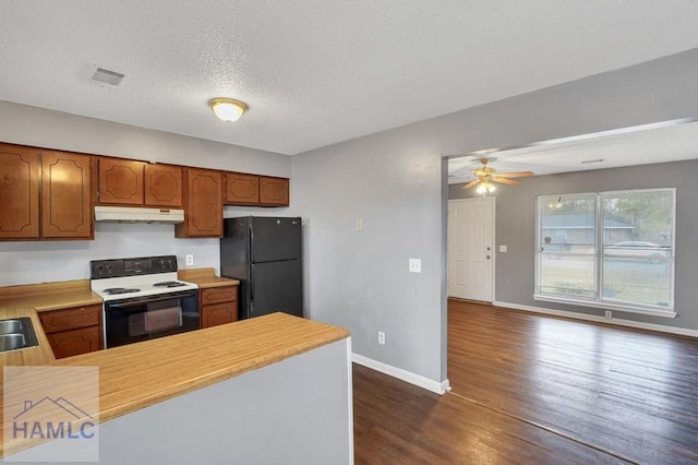 kitchen with kitchen peninsula, black fridge, a textured ceiling, dark hardwood / wood-style floors, and white range with electric cooktop