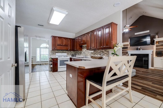 202 Red Bluff Cir, Rincon, GA 31326 - kitchen featuring gas range gas stove, light tile patterned flooring, a peninsula, light countertops, and tasteful backsplash