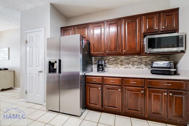 202 Red Bluff Cir, Rincon, GA 31326 - kitchen featuring stainless steel appliances, light countertops, light tile patterned flooring, decorative backsplash, and a textured ceiling