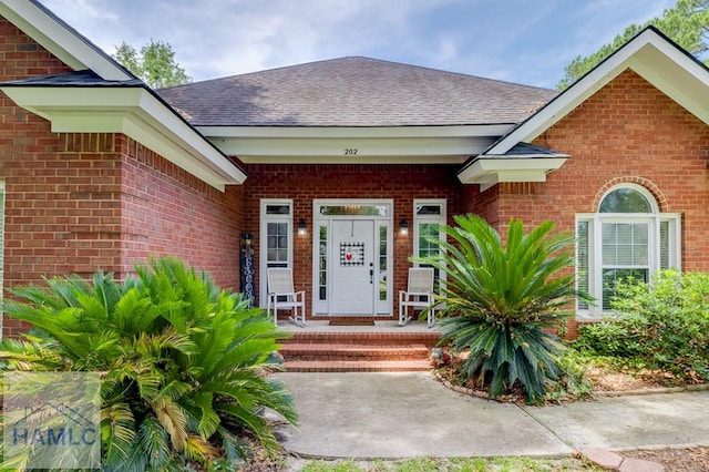 202 Red Bluff Cir, Rincon, GA 31326 - entrance to property featuring brick siding, roof with shingles, and covered porch