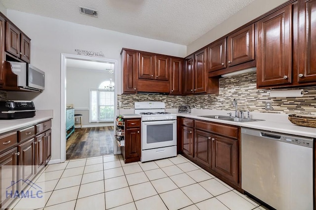 202 Red Bluff Cir, Rincon, GA 31326 - kitchen featuring dishwasher, white range with gas stovetop, light countertops, tasteful backsplash, and a textured ceiling