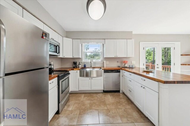 1019 Bacon Rd, Hinesville, GA 31313 - kitchen featuring stainless steel appliances, wood counters, a sink, a peninsula, and white cabinetry