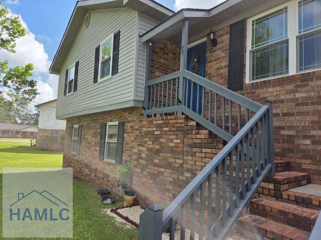 1019 Bacon Rd, Hinesville, GA 31313 - view of side of home featuring brick siding and a lawn