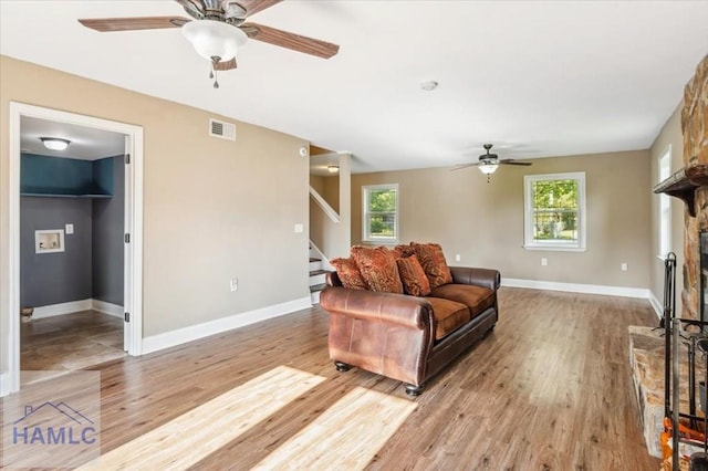 1019 Bacon Rd, Hinesville, GA 31313 - living room with ceiling fan, light wood-style floors, stairs, and plenty of natural light