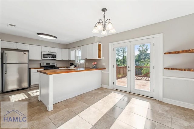 1019 Bacon Rd, Hinesville, GA 31313 - kitchen featuring appliances with stainless steel finishes, wooden counters, french doors, a chandelier, and baseboards