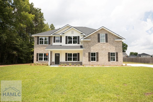 view of front of property featuring a front lawn, fence, and brick siding