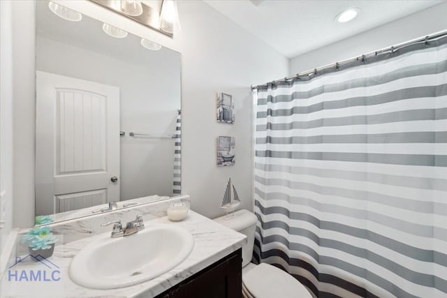 bathroom with toilet, curtained shower, and vanity
