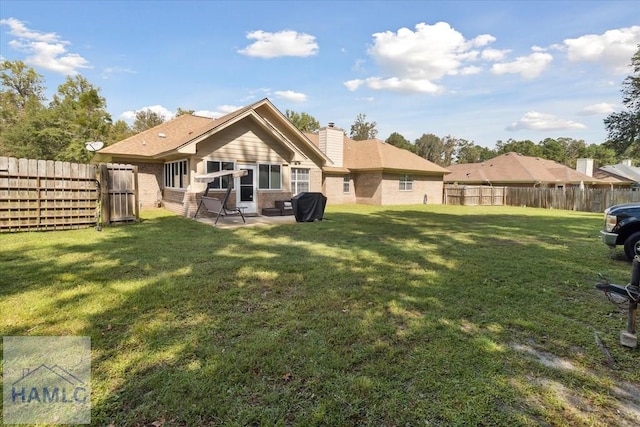 rear view of house with a patio area and a lawn