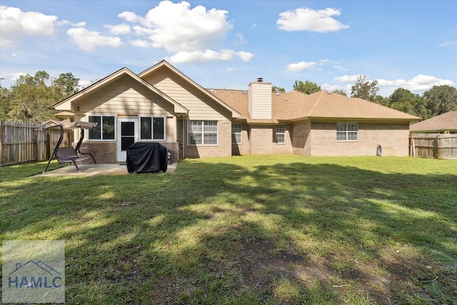 rear view of house featuring a patio area and a yard