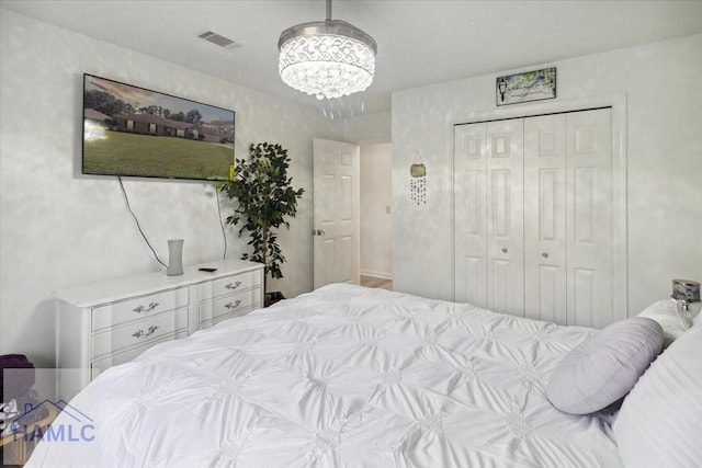 bedroom featuring an inviting chandelier and a closet