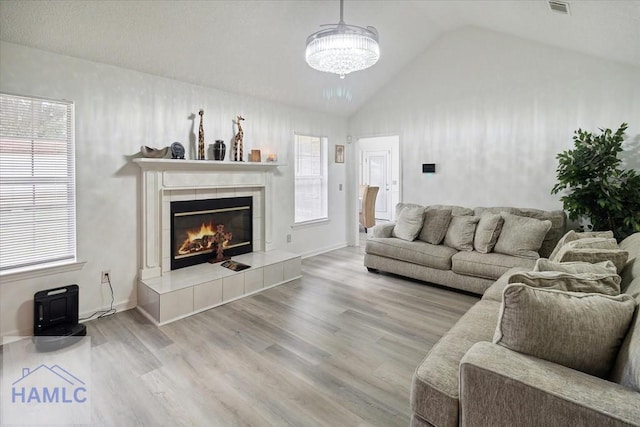 living room with hardwood / wood-style flooring, vaulted ceiling, and plenty of natural light