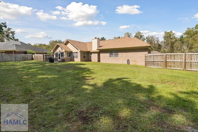 rear view of house featuring a lawn