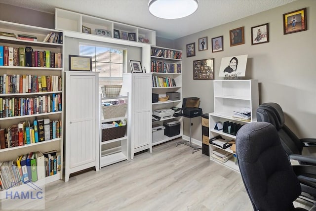 office space featuring a textured ceiling and light hardwood / wood-style flooring