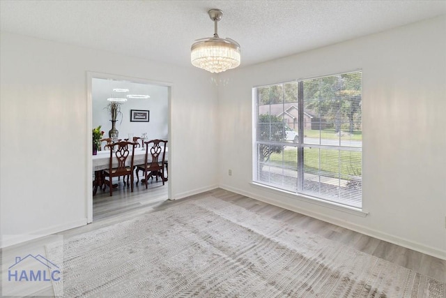 interior space featuring hardwood / wood-style floors, a textured ceiling, and an inviting chandelier